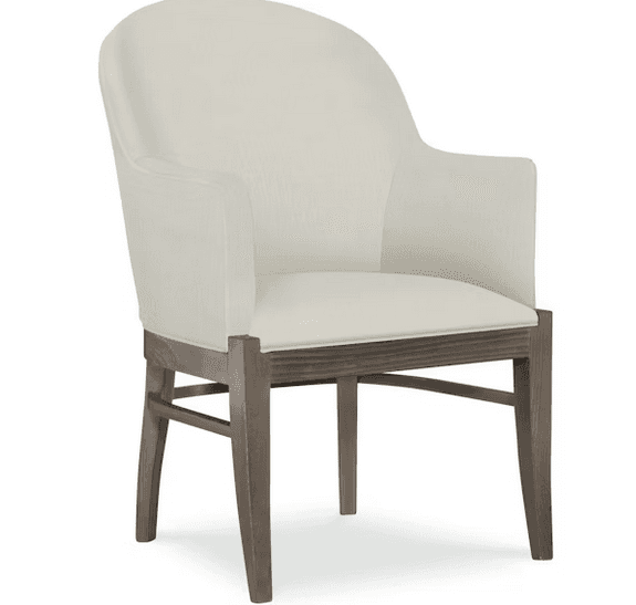 A cream-colored armchair with a high, curved back and upholstered arms. The seat is also upholstered in the same fabric. The frame and legs are made of wood with a weathered, gray-brown finish. The legs have a slightly tapered profile. — 3D model