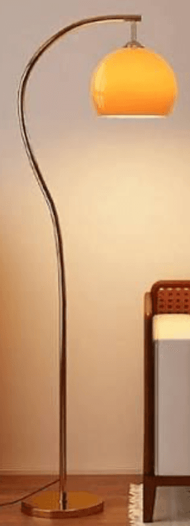 A modern arc floor lamp featuring a curved silver-toned metal stem, a round brushed metal base, and a spherical frosted amber glass shade. The stem has a gentle S-curve before arcing over to hold the shade. — 3D model