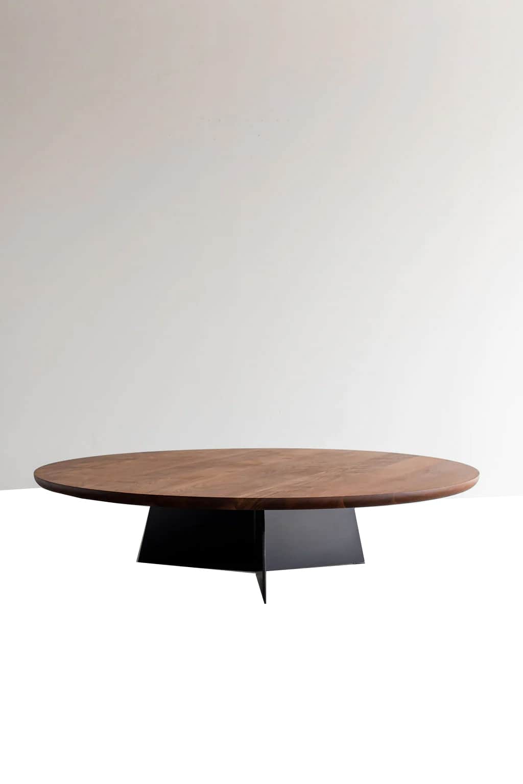 A modern coffee table with an oval-shaped wooden top and a distinctive geometric metal base. The tab… — 3D model