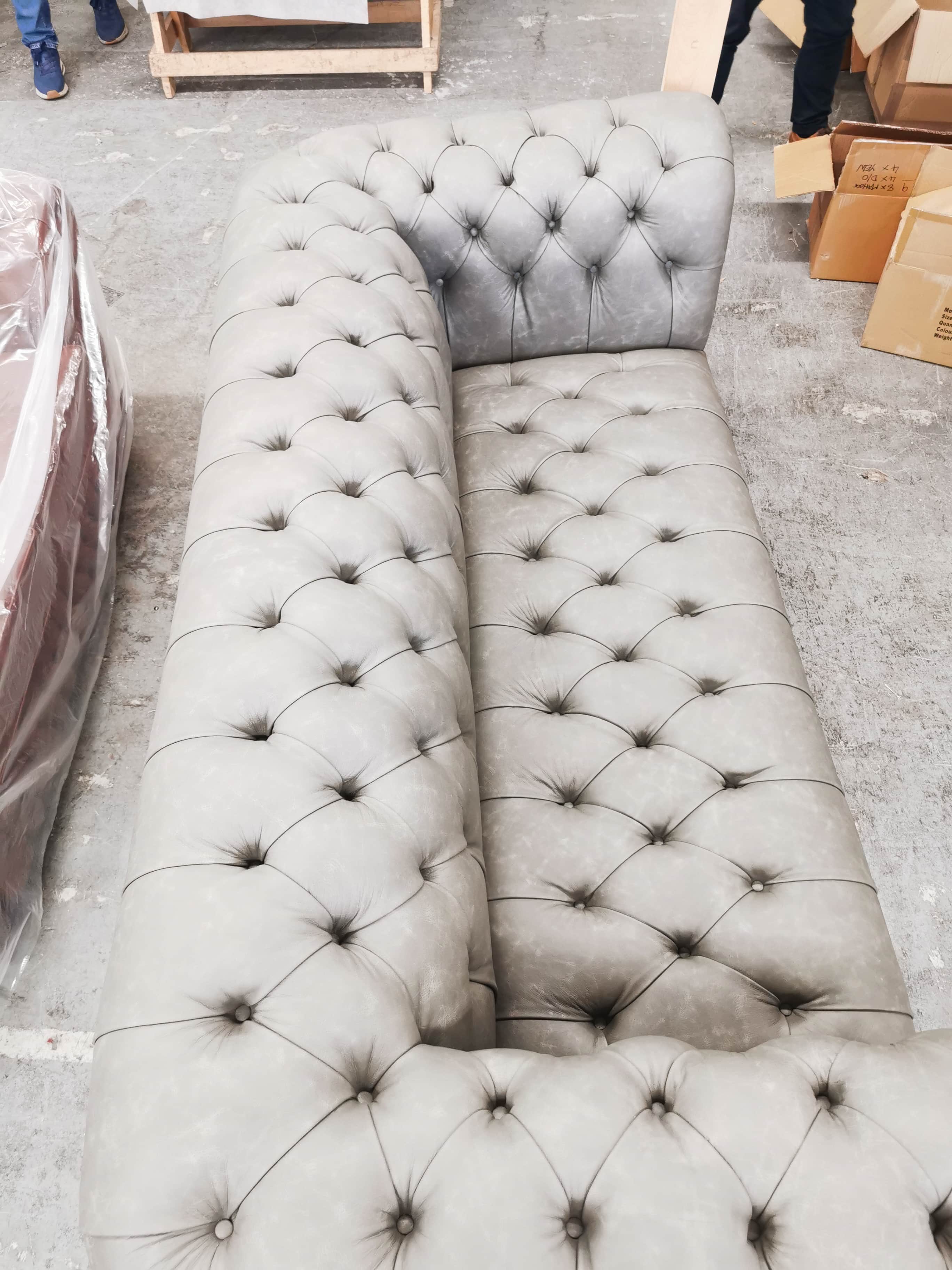 A classic Chesterfield sofa upholstered in a light grey leather-look material, featuring deep button… — free GLTF 3D model
