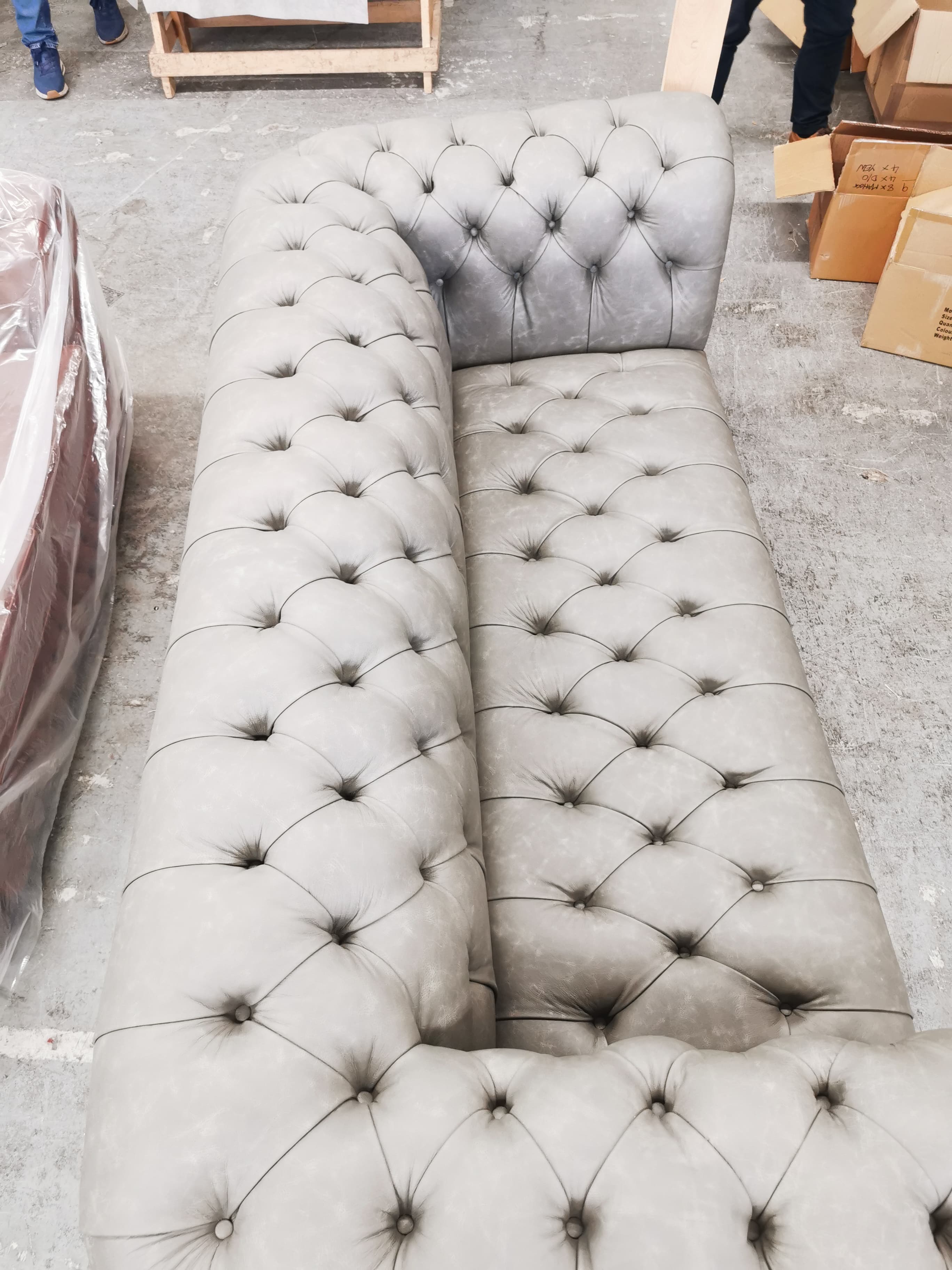 A classic Chesterfield sofa upholstered in a light grey leather-look material, featuring deep button tufting across the backrest, rolled arms, and the front apron. It has a continuous single seat cushion. — 3D model