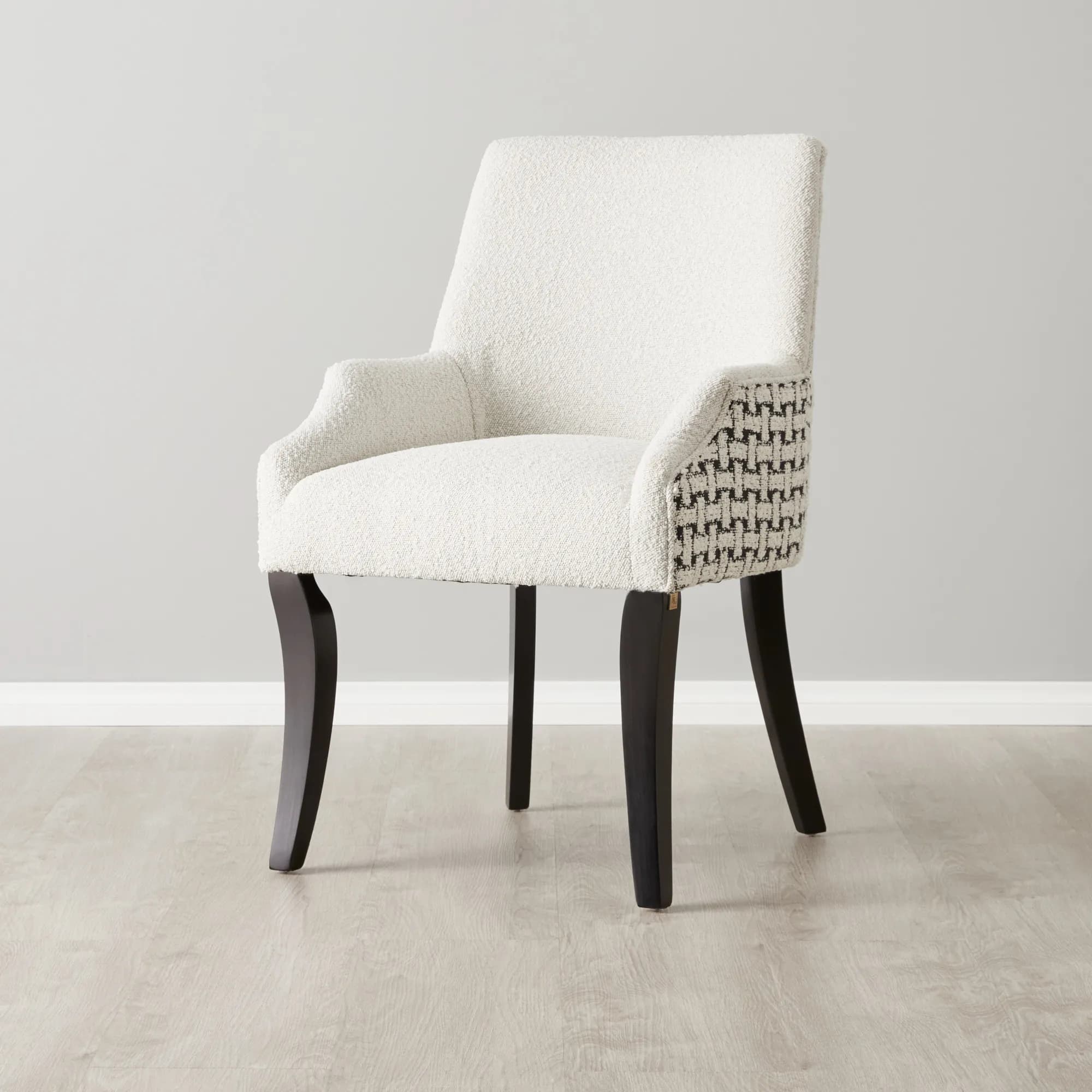 A white upholstered accent chair with a boucle texture on the seat and back, and a geometric patterned fabric on the sides. It features curved armrests and four dark, tapered legs. — 3D model