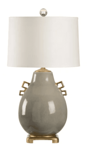 A table lamp featuring a grey, glazed ceramic gourd-shaped base with decorative brass-finished geometric handles and a square pedestal. It is topped with a white fabric drum shade and a clear spherical finial. — 3D model