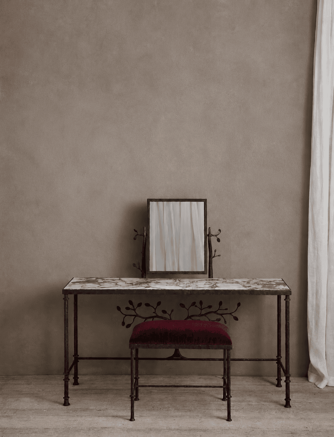 A decorative vanity set consisting of a dressing table with a marble top and a matching upholstered stool, both featuring dark metal frames with botanical scrollwork and an adjustable mirror. — 3D model