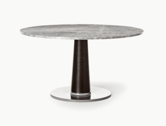 A contemporary round dining table featuring a light grey marble top with natural veining. It is supported by a single, dark brown, vertically ribbed pedestal column which broadens towards a circular polished chrome or stainless steel base. — 3D model