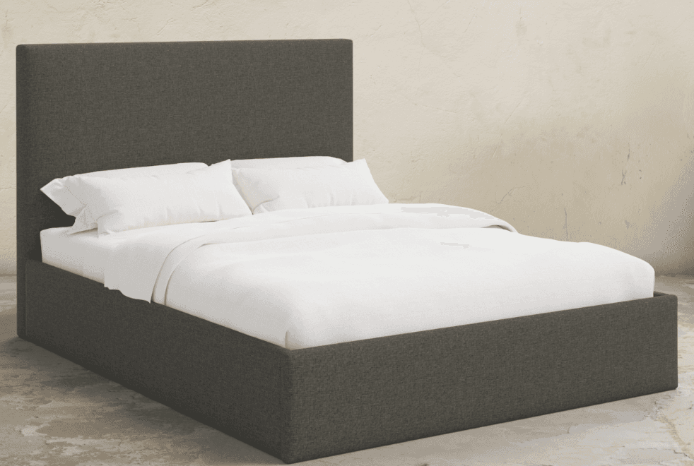 A contemporary platform bed fully upholstered in a dark gray fabric, featuring a rectangular headboard and a low-profile frame. The bed is presented with white bedding. — 3D model