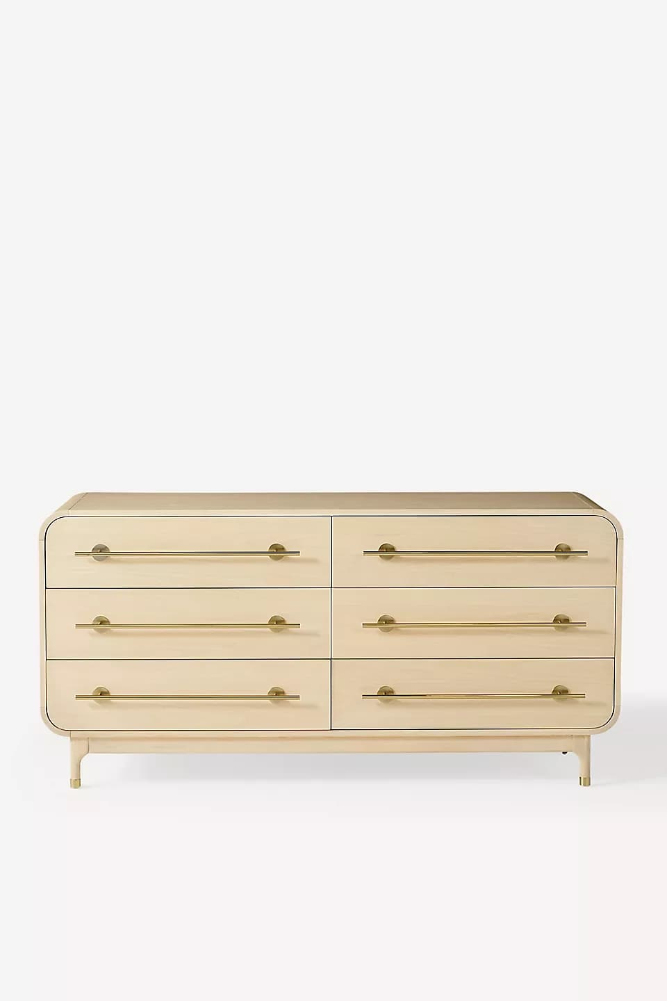A modern six-drawer dresser featuring a light wood finish and elegant brass bar pulls. The piece has soft, rounded edges on the top and sides, giving it a streamlined appearance. It stands on four tapered legs, also in light wood, with brass caps. The dresser is symmetrical, with three drawers stacked vertically on each side, offering ample storage. — 3D model