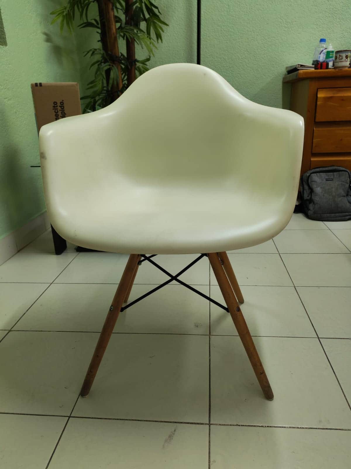 An off-white, molded plastic armchair with integrated armrests and a 'Eiffel Tower' style base consi… — 3D model