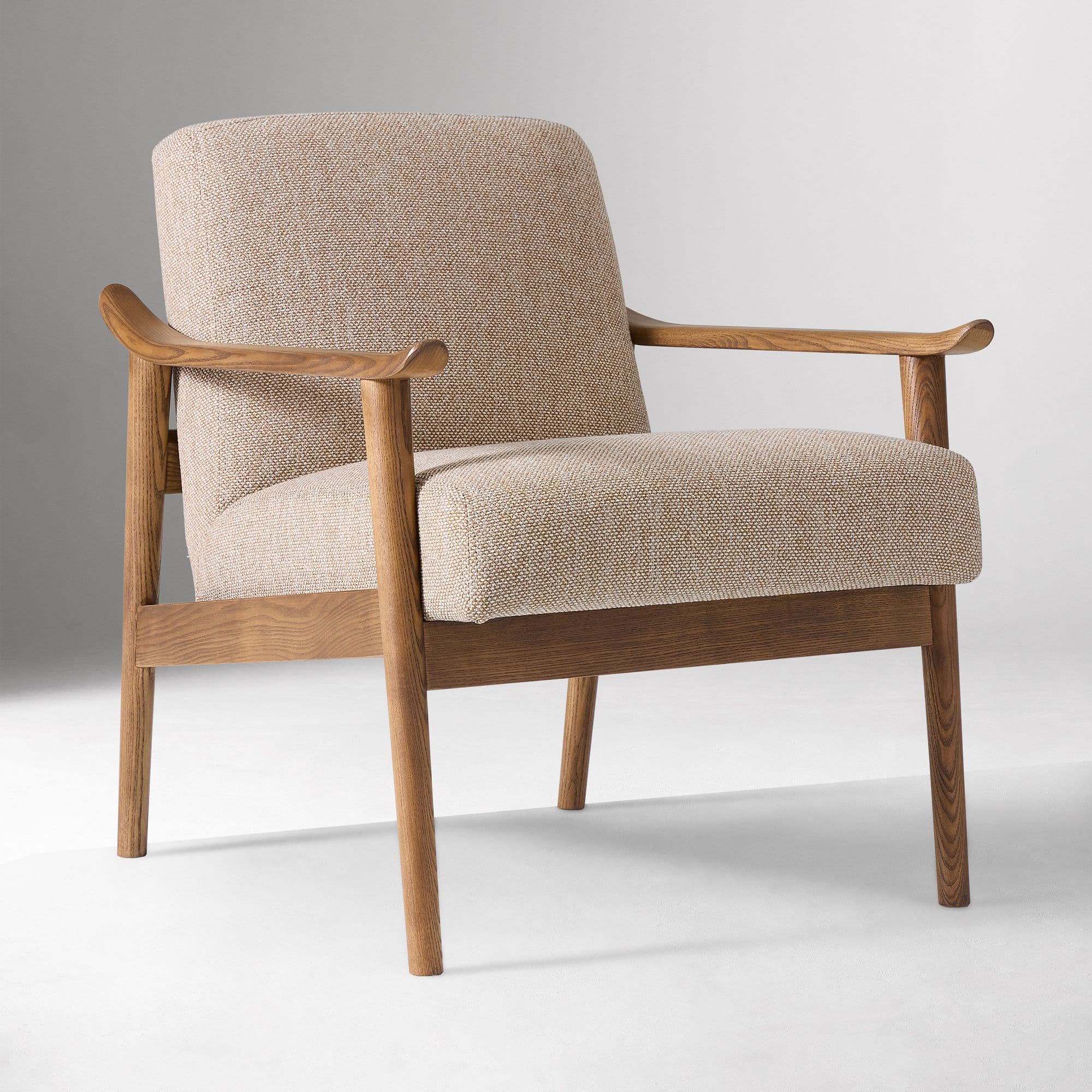 A modern armchair featuring an exposed light-toned wooden frame and upholstered seat and back cushions in a light beige, textured fabric. The armrests are elegantly curved, and the legs are tapered. — 3D model