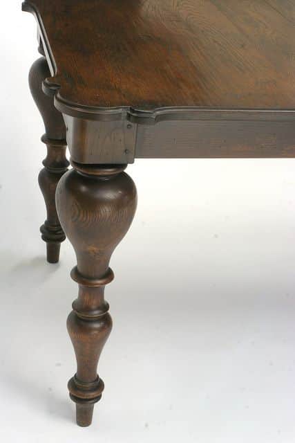 A close-up view of a traditional dark wood table, likely a dining table, showcasing its ornate turne… — 3D model