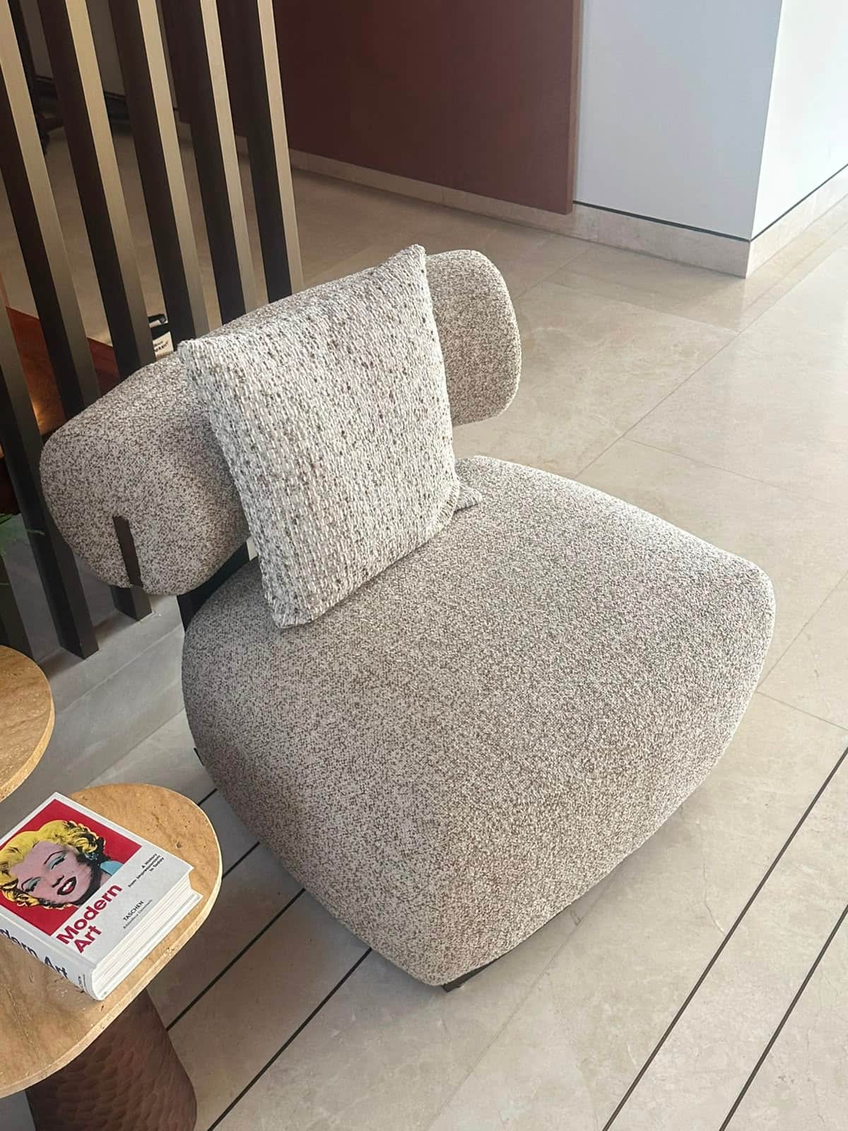 A modern, sculptural lounge chair upholstered in a light, textured boucle fabric, featuring a distin… — 3D model