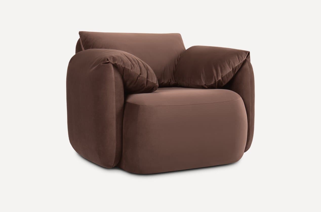 A contemporary armchair with plush upholstery and generous cushioning. The armchair features rounded edges and deep, inviting seat and backrest areas, complemented by loose back cushions that add to its comfortable and relaxed aesthetic. It is presented against a neutral background. — 3D model