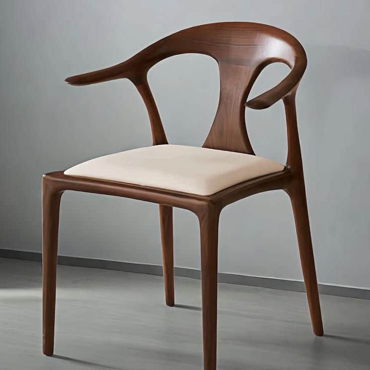 A modern wooden dining armchair with a sculptural dark brown frame and an upholstered cream-colored… — free GLB 3D model