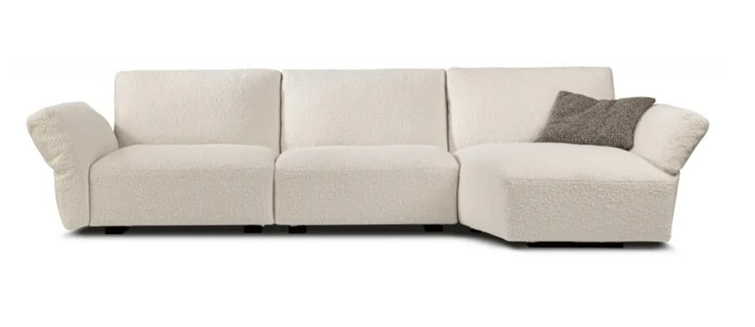 An L-shaped sectional sofa upholstered in a textured bouclé fabric, featuring a long, integrated chaise lounge section. The sofa has a contemporary design with soft, rounded edges, wide armrests, and plush, inviting cushions. Its off-white color and low profile suggest a modern and comfortable aesthetic. — 3D model