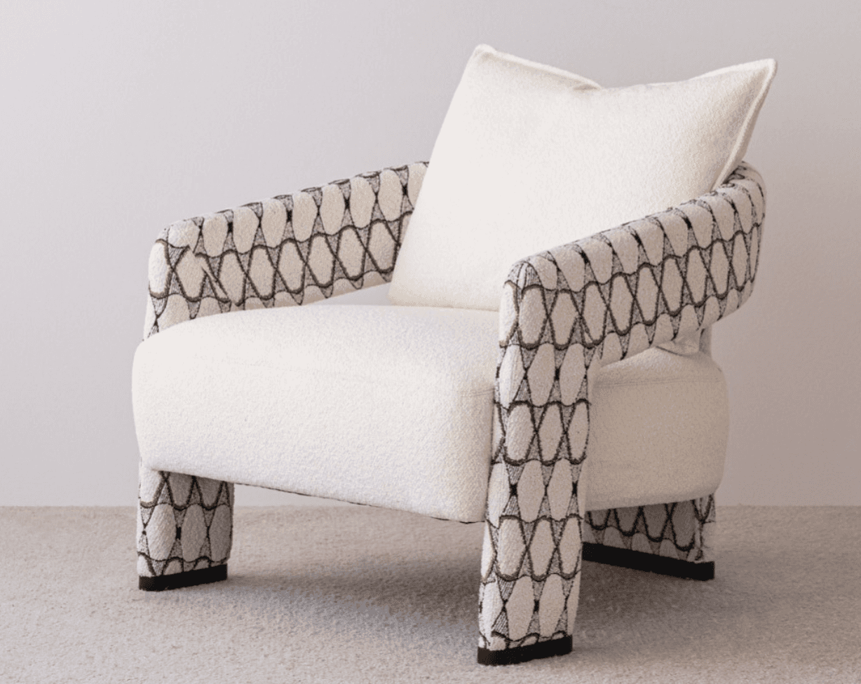 A contemporary upholstered armchair featuring a plush, light-colored bouclé fabric on the seat and b… — 3D model