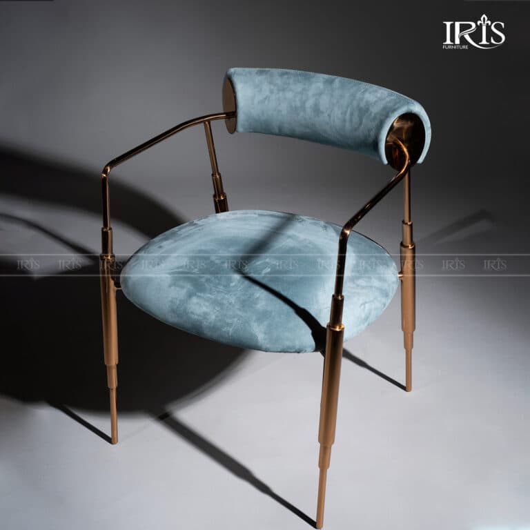 A contemporary armchair featuring light blue velvet upholstery on its circular seat and cylindrical bolster backrest, supported by a slender polished rose gold-tone metal frame and tapered legs. — 3D model