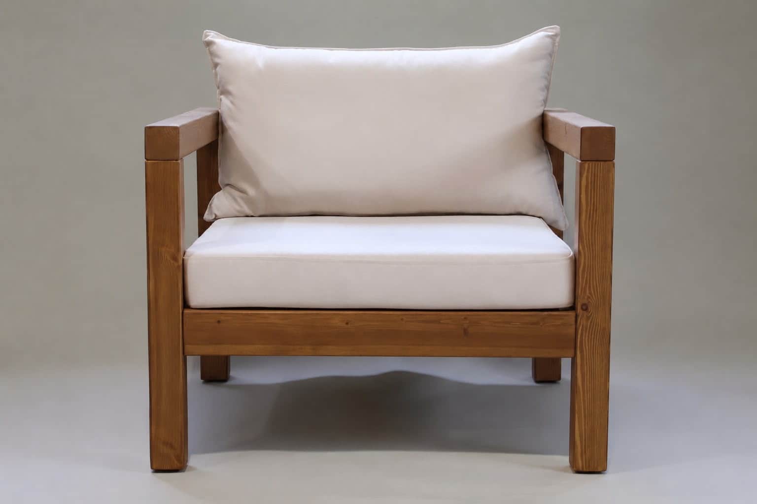 A robust armchair featuring a rectilinear frame constructed from solid, warm-toned wood, likely pine… — 3D model