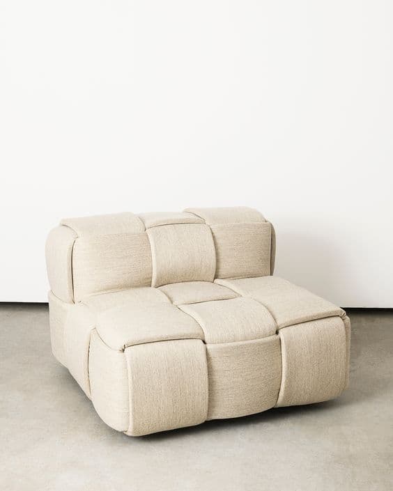 A modular armchair with a unique woven design. The armchair features a low profile and is upholstered in a textured fabric. The construction appears to be modular, with individual cushioned sections forming the seat and backrest. — 3D model