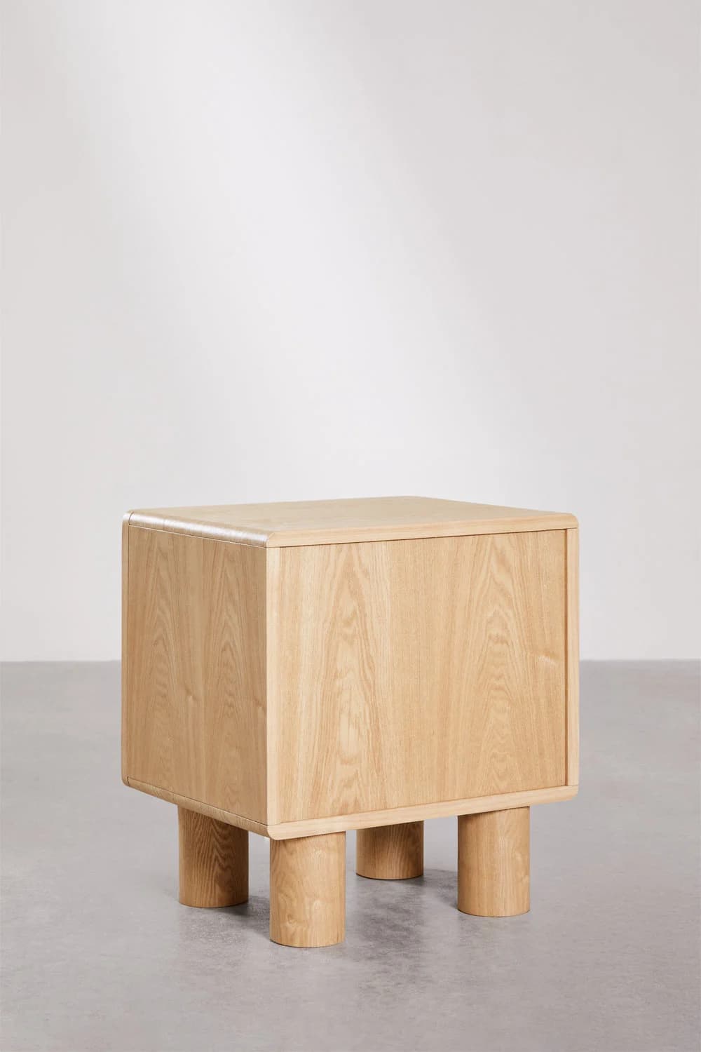 A contemporary nightstand with a cuboid main body and four cylindrical legs. The top and side panels have gently rounded edges. The grain of the wood is clearly visible, suggesting a natural wood construction. — 3D model