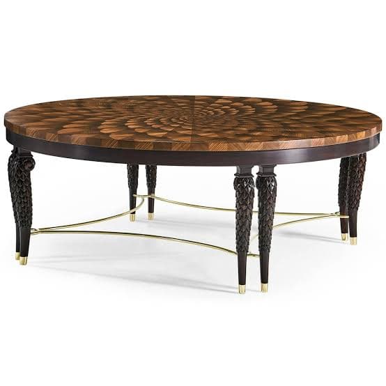 A sophisticated round coffee table featuring an intricately patterned marquetry top made from various wood veneers, creating a radial, spiraling design. The table is supported by four dark, elaborately carved and tapered legs with brass ferrules, connected by a delicate brass stretcher base. The overall aesthetic is one of luxury and fine craftsmanship. — 3D model