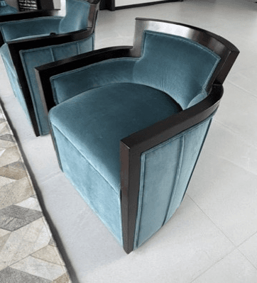 A pair of teal velvet upholstered club chairs with a dark exposed wooden frame, featuring a curved barrel back design and vertical channel tufting on the exterior. — 3D model