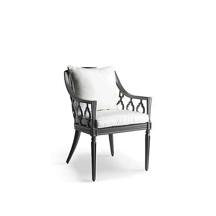 A dark-colored, ornate cast metal armchair featuring intricate decorative side panels and legs. The chair is furnished with light-colored, removable cushions on both the seat and backrest, suggesting comfort and aesthetic appeal. Its design combines classical elements with practical cushioning. — 3D model