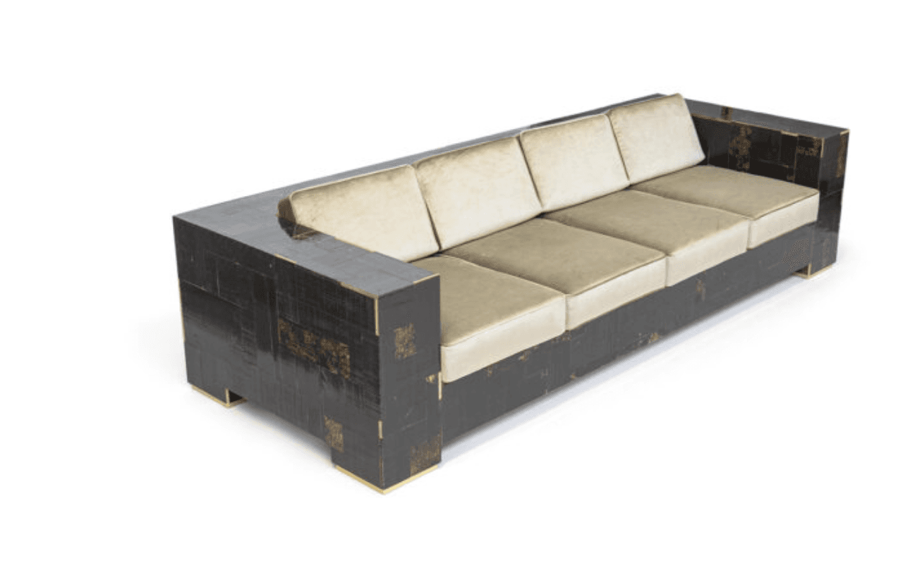 A contemporary four-seater sofa with a low profile and geometric design. The sofa features a dark, textured exterior with metallic gold accents and plush, light-colored seat and back cushions. The frame appears to be constructed from multiple rectangular panels. The armrests are integrated into the main body of the sofa, forming a continuous rectilinear form. — 3D model