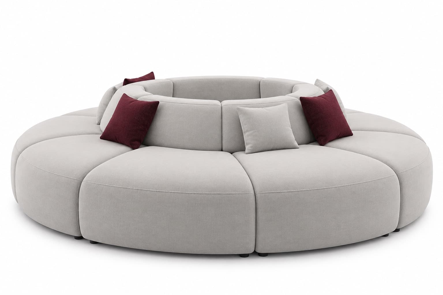A large, contemporary modular circular sofa upholstered in light grey fabric, featuring individual curved sections that form a full ring. It includes integrated low-profile backrests and is accented with small square throw pillows in light grey and dark red. — 3D model