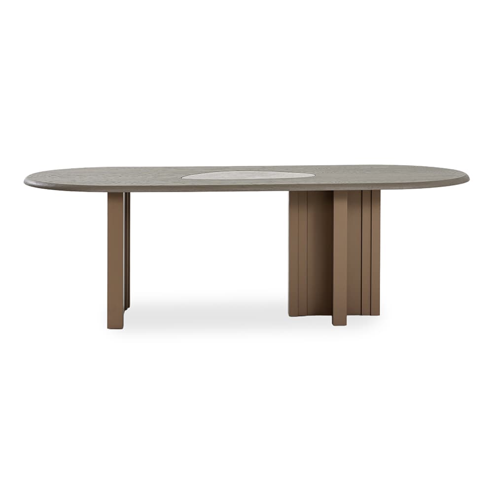 A contemporary oval dining table featuring a light grey wood-grain tabletop with a central lighter-toned, possibly ceramic or stone, inlay. The table is supported by an asymmetrical base design, with one side comprising two rectangular post legs and the other side featuring a solid, fluted, or slatted pedestal base. Both base elements are a uniform taupe-brown color. — 3D model