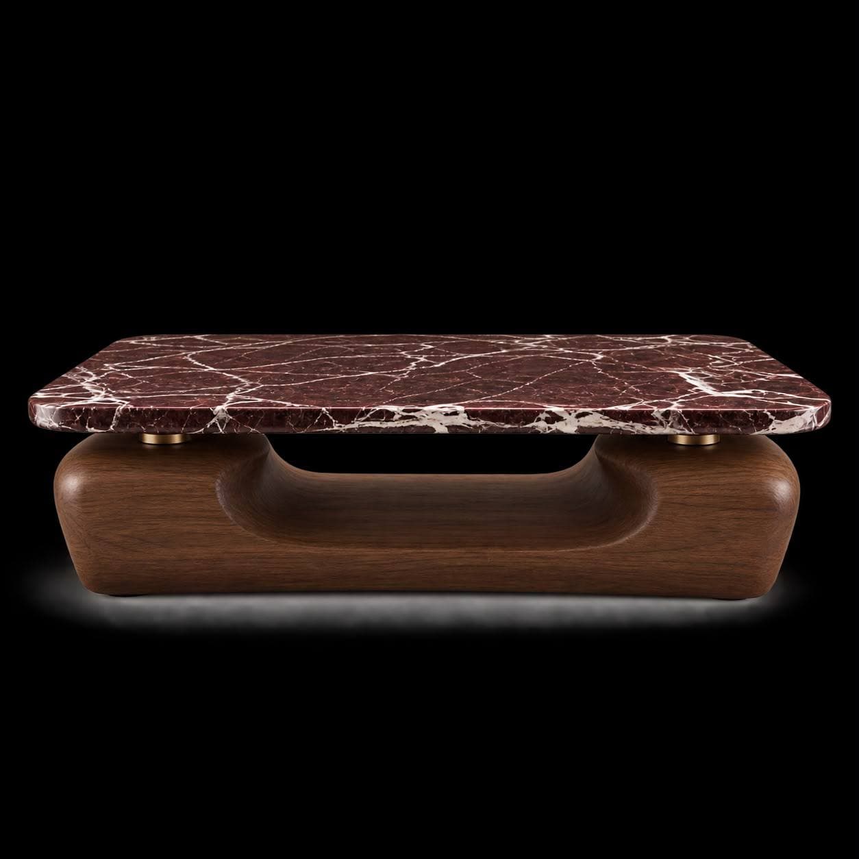 A contemporary coffee table featuring a rectangular, red veined marble top with rounded corners, supported by a sculptural, curvilinear dark walnut wood base with brass connectors. — 3D model