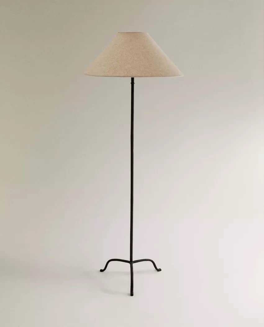 A tall, slender floor lamp with a conical lampshade. The base is a three-legged, wrought-iron struct… — 3D model