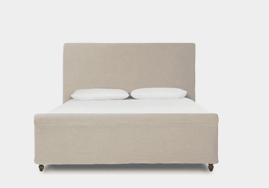 An upholstered bed featuring a rectangular headboard and a fabric-wrapped frame, supported by turned… — free GLTF 3D model