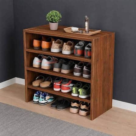 A compact, three-tier open shelving unit featuring a medium brown wood-look laminate finish. The uni… — 3D model