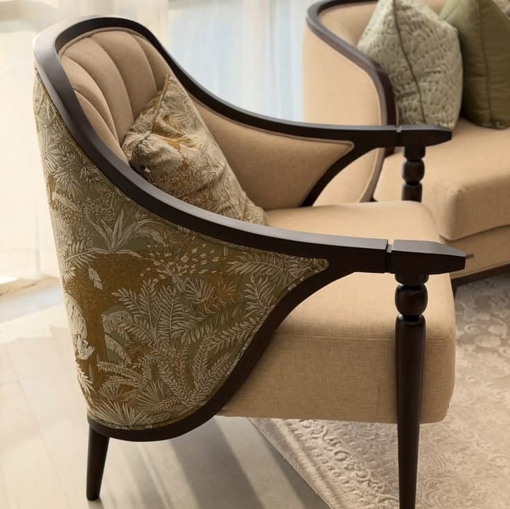 A classically inspired upholstered armchair featuring a curved, exposed dark wood frame, complemented by light beige fabric on the seat and inner back. The outer back and side panels are adorned with a lush green and gold tropical or botanical pattern, and the chair includes a matching decorative throw pillow. — 3D model