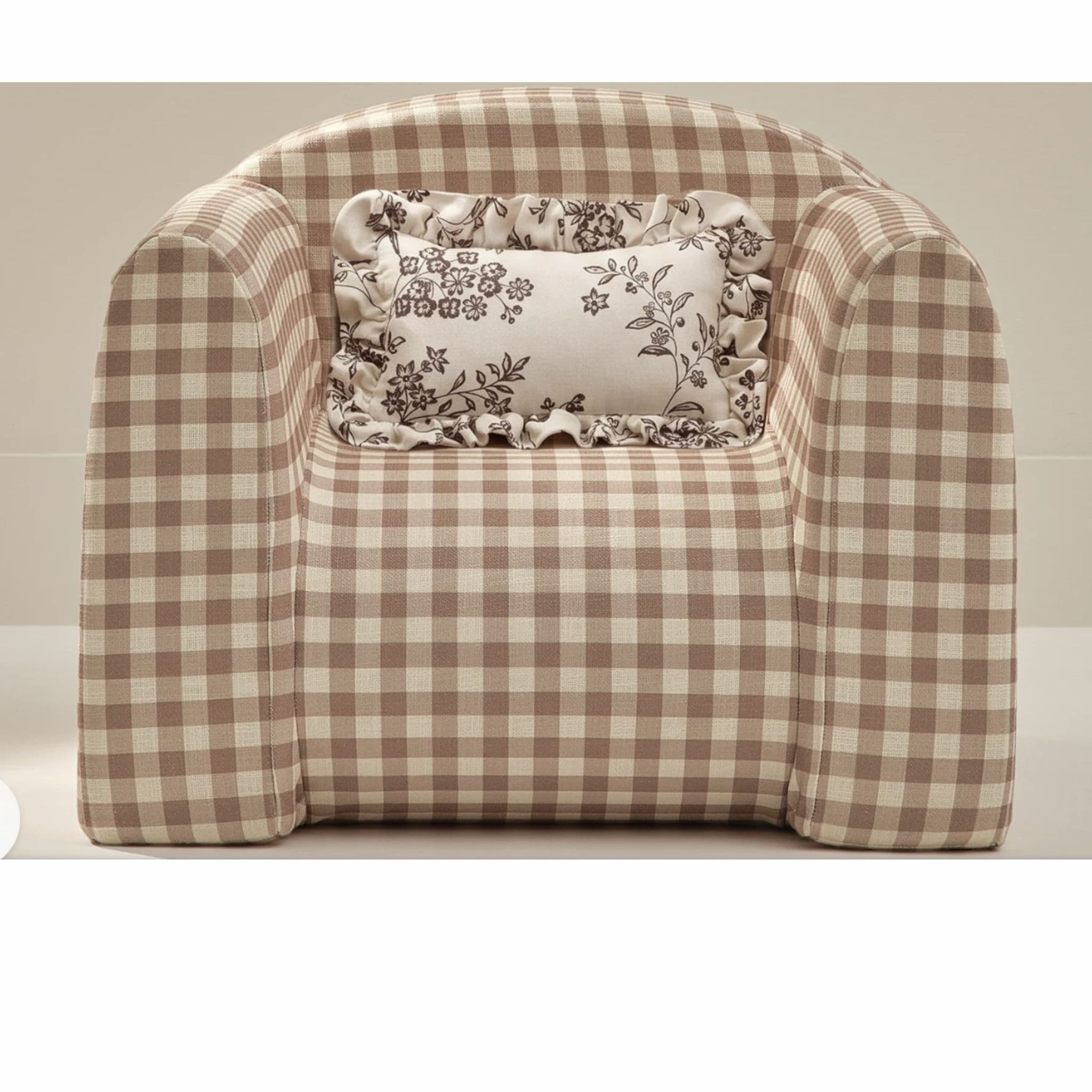An upholstered armchair featuring a beige and brown gingham pattern, with a rounded barrel-style back and integrated arms. It includes a decorative toss pillow with a floral print and ruffled edges. — 3D model