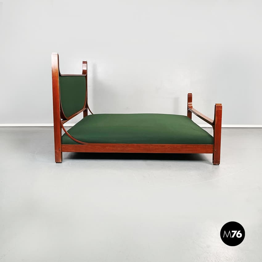 A daybed with a wooden frame and a green upholstered mattress. The frame has a rectangular base with two vertical supports at the head and a single vertical support at the foot. The headboard is curved and upholstered in green fabric. The armrests are integrated into the frame and extend from the headboard supports. — 3D model