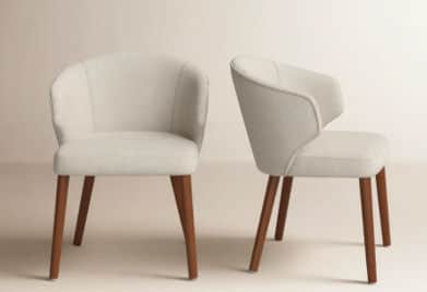 An upholstered armchair featuring a rounded, continuous backrest that flows into integrated armrests… — 3D model