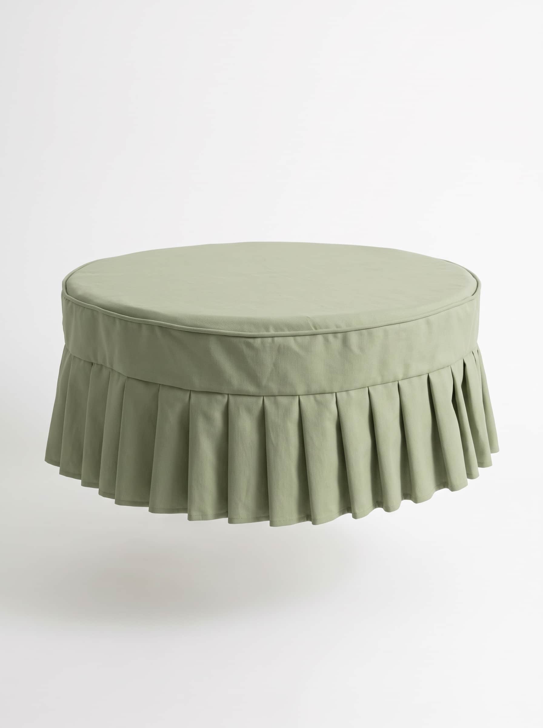A round, light green upholstered ottoman featuring a pleated skirt base and a flat cushioned top. — 3D model
