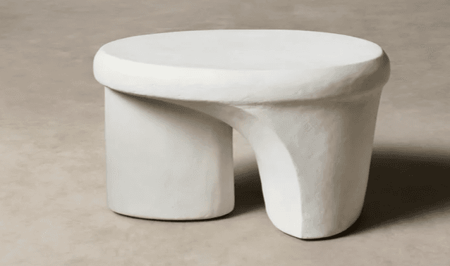 An off-white sculptural table with a rounded top and a distinctive, asymmetrical, and curved base, featuring a textured finish. — 3D model