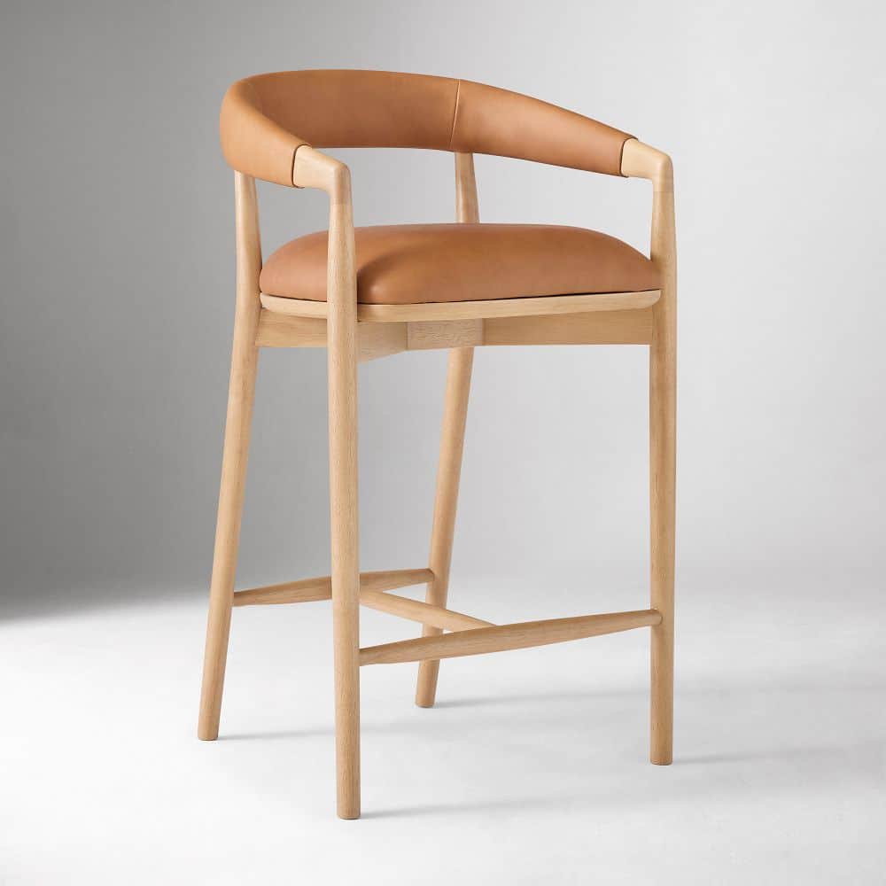 A bar stool with a curved backrest and armrests, featuring a wooden frame and leather upholstery for… — 3D model
