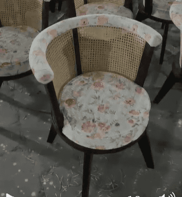 A stylish accent chair featuring a dark stained wooden frame, a rounded cane backrest, and a comfort… — 3D model