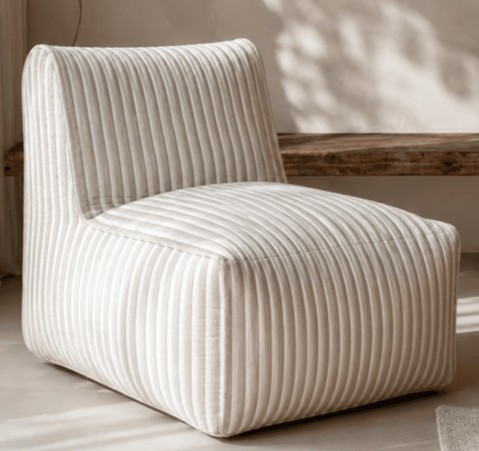 An armless, single-seat upholstered lounge chair featuring a vertical striped pattern in alternating light beige/cream and white. It has a low-profile back integrated with the seat, and a compact, blocky form with softly rounded edges. — 3D model