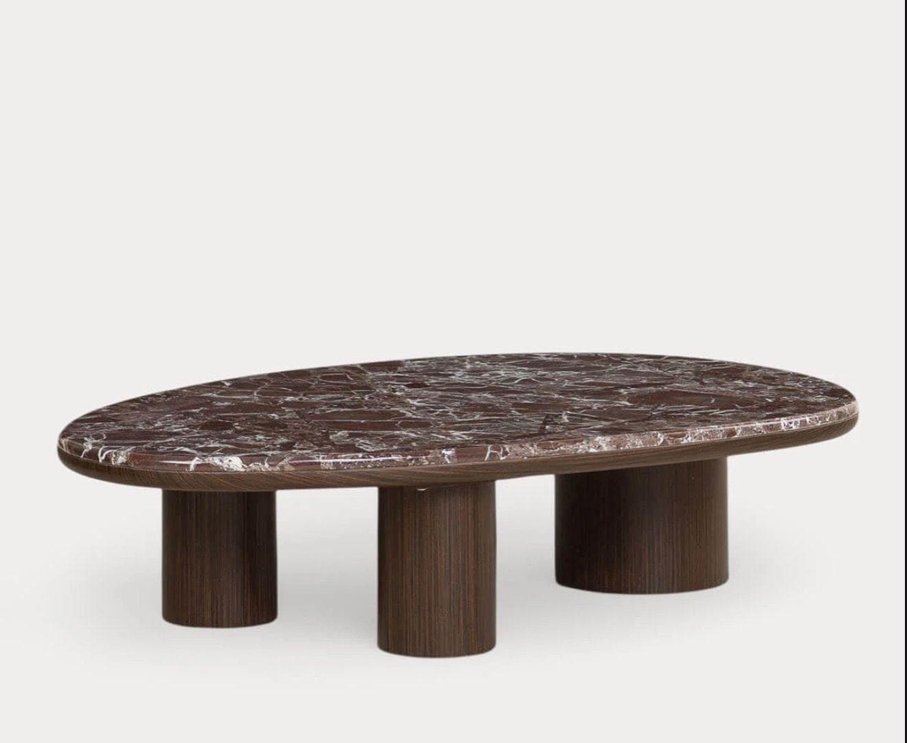 A contemporary coffee table featuring a polished, organically shaped marble tabletop in reddish-brown with prominent white and grey veining. The table is supported by three robust, cylindrical legs made from dark wood with a visible vertical grain, providing a sculptural and stable base. — 3D model