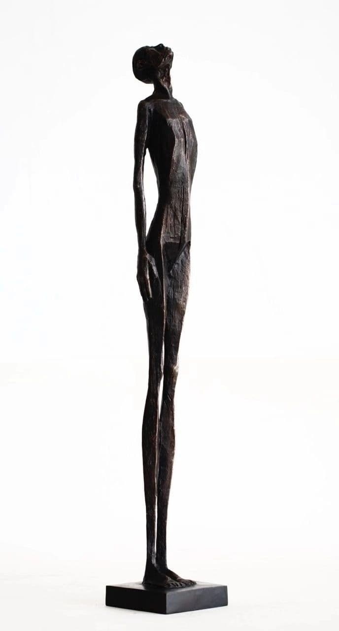 A tall, slender, abstract figurative sculpture depicting a human-like form with an elongated body and a head tilted upwards, crafted from a dark, textured material and mounted on a minimalist rectangular base. — 3D model