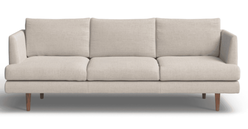 A full-front view of a contemporary three-seater sofa upholstered in a light beige, textured fabric. The sofa features a minimalist design with three removable seat cushions and three removable back cushions. It is supported by short, tapered wooden legs, and the armrests are low and slightly rounded, blending seamlessly into the sofa's frame. — 3D model