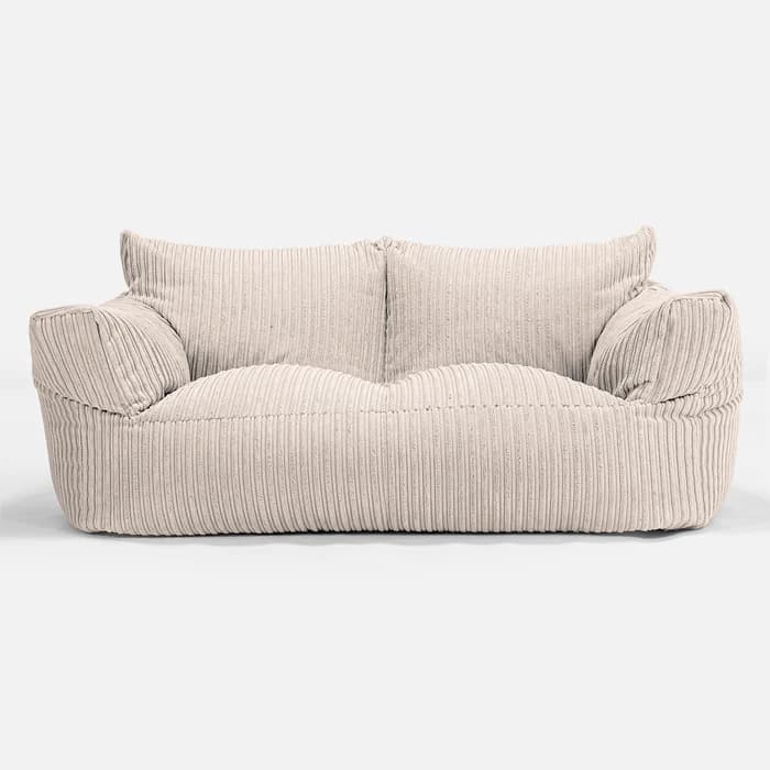 A two-seater sofa with a relaxed, beanbag-like construction. The upholstery features prominent vertical corduroy-style ribbing. It has soft, rounded armrests and a generously padded seat and back cushions, with two square-shaped back cushions visible. — 3D model