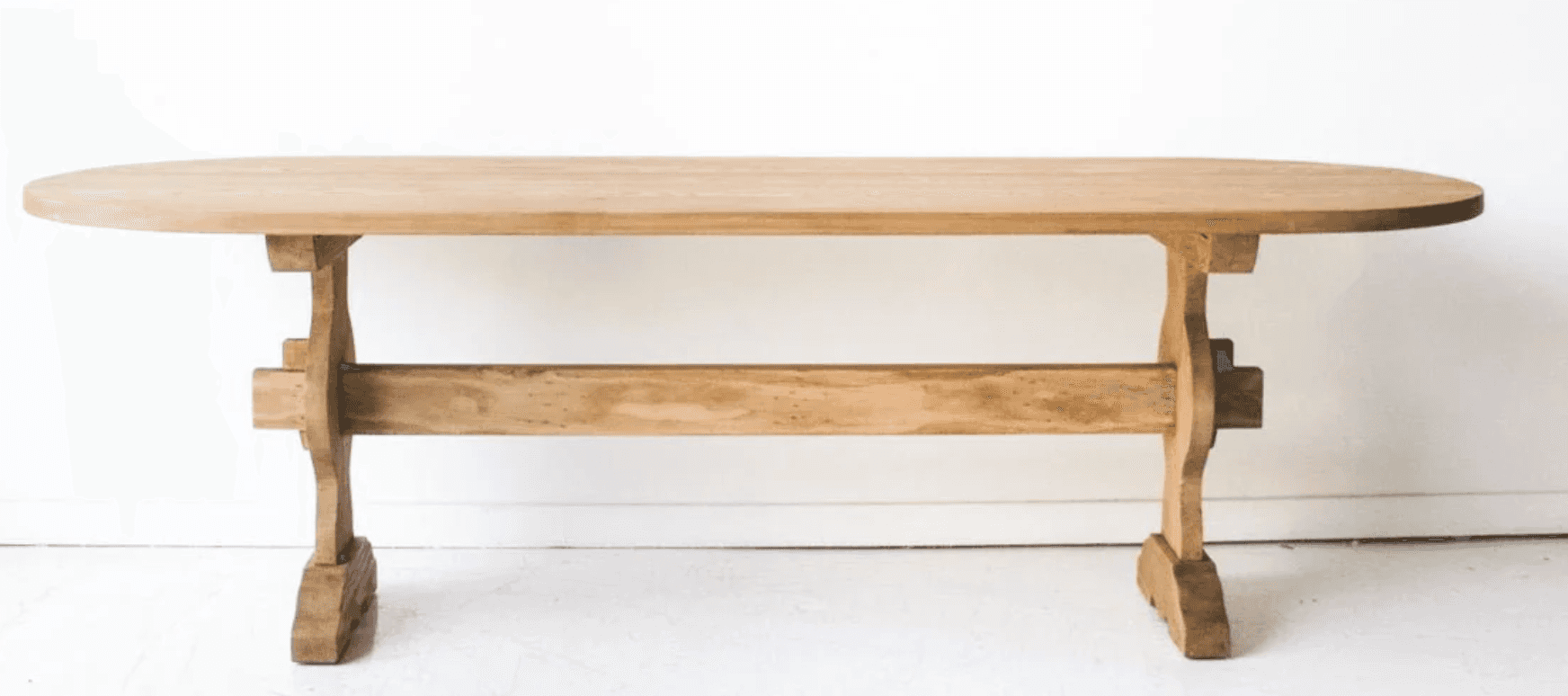 An oval dining table constructed from light-toned wood, featuring a distinctive trestle base. The ta… — 3D model