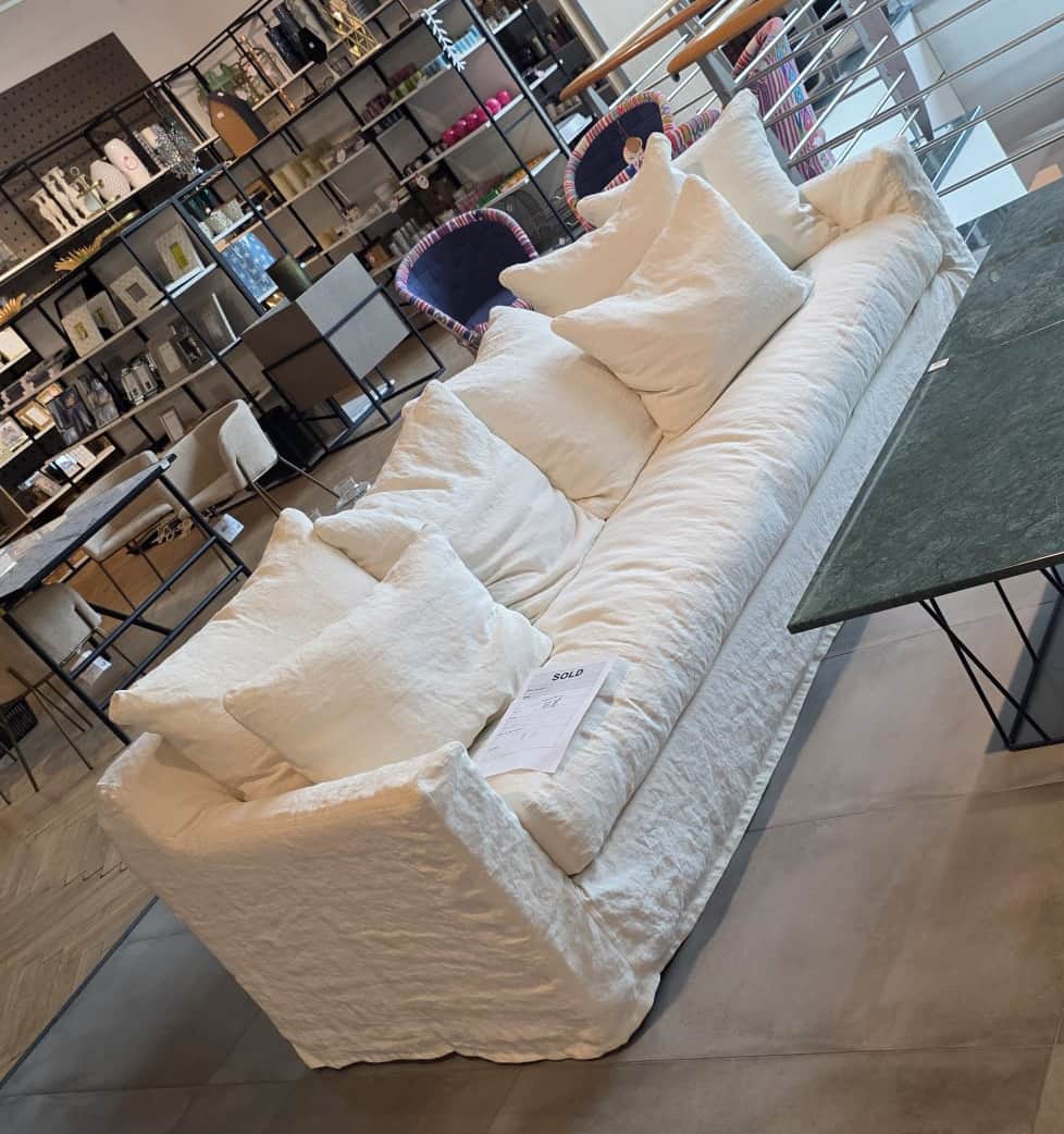 A long, low-profile sofa with a slipcover design. The sofa features plush seat cushions and a genero… — free GLTF 3D model