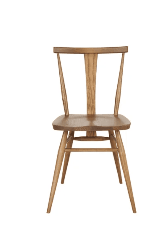 A light-colored solid wood dining chair featuring a spindle back design with a contoured seat and splayed legs. The chair is made from natural wood, likely oak or ash, with visible grain patterns. — 3D model