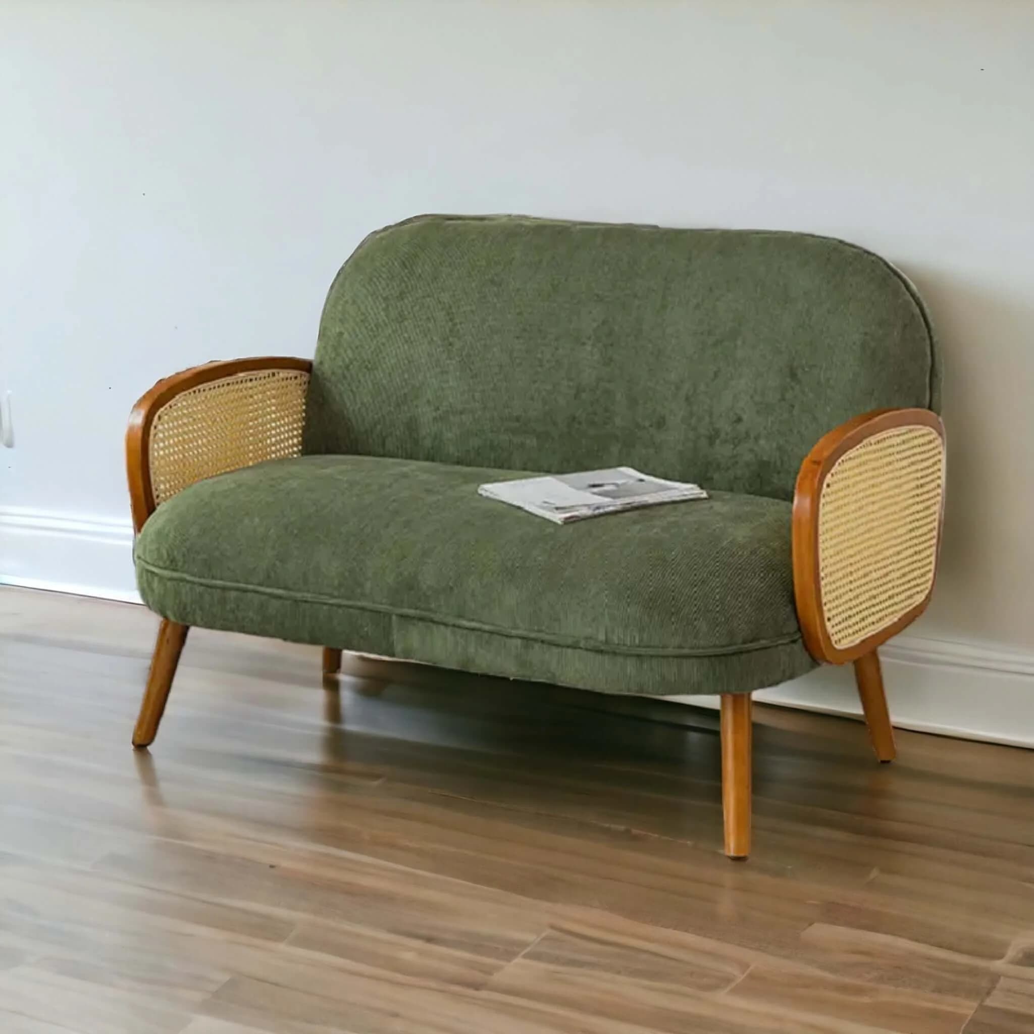 A contemporary loveseat upholstered in a ribbed green fabric, featuring distinctive armrests made from light-toned wood with integrated cane webbing panels. It has a rounded backrest and seat, supported by four tapered wooden legs. — 3D model